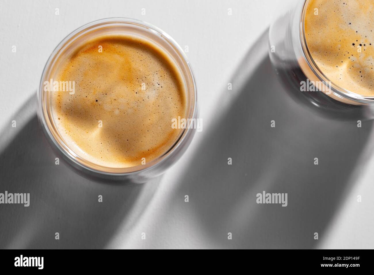 Americano Kaffee in Glas Tassen auf weißem Hintergrund mit lang Schatten  Stockfotografie - Alamy