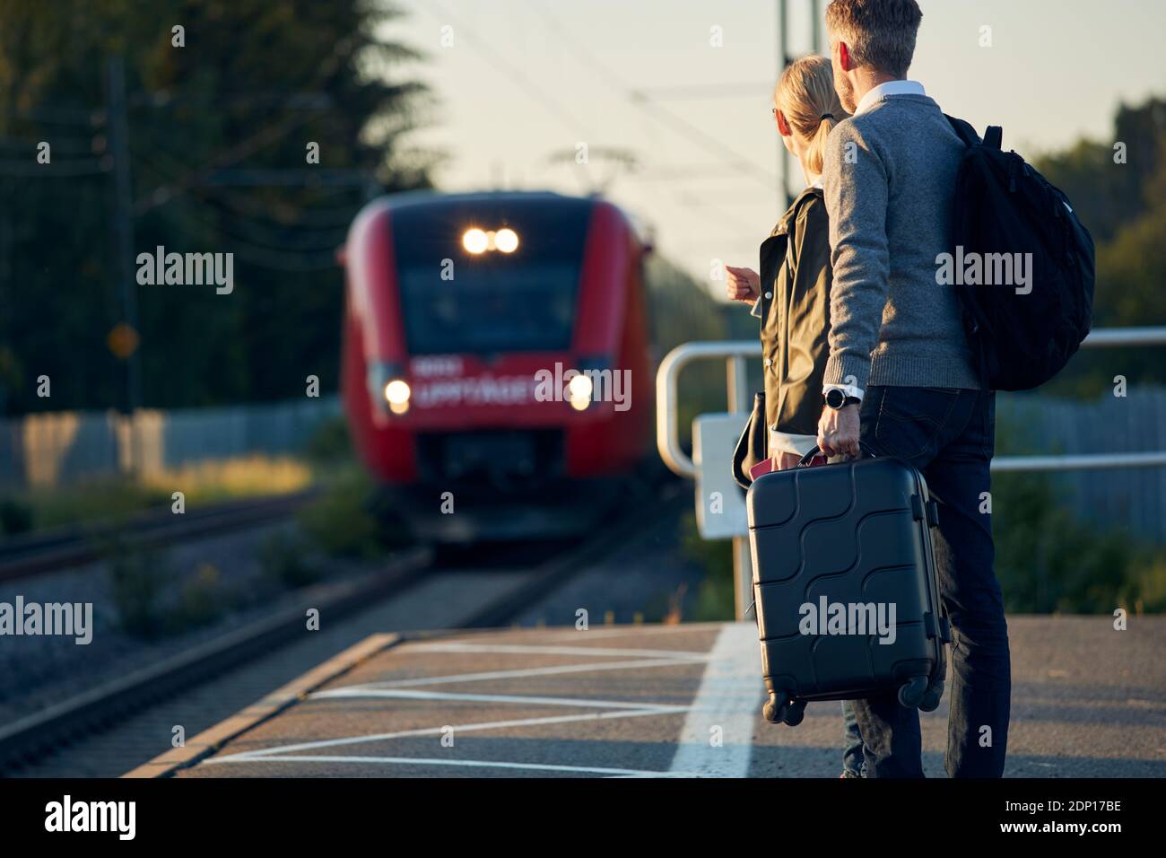 Pärchen warten am Bahnhofsplatz Stockfoto