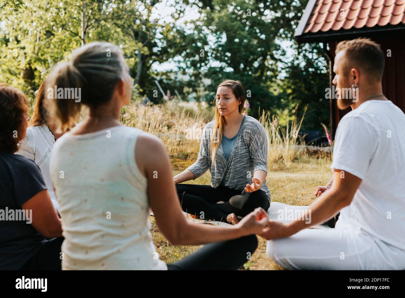 Menschen meditieren im Garten Stockfoto
