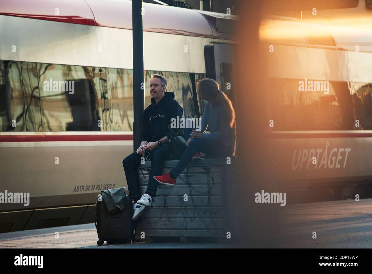 Pärchen warten am Bahnhofsplatz Stockfoto