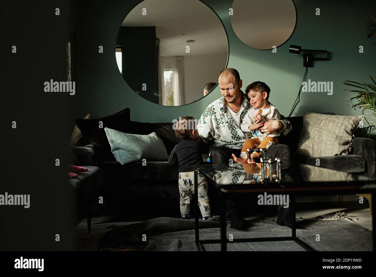Vater mit Kindern im Wohnzimmer Stockfoto