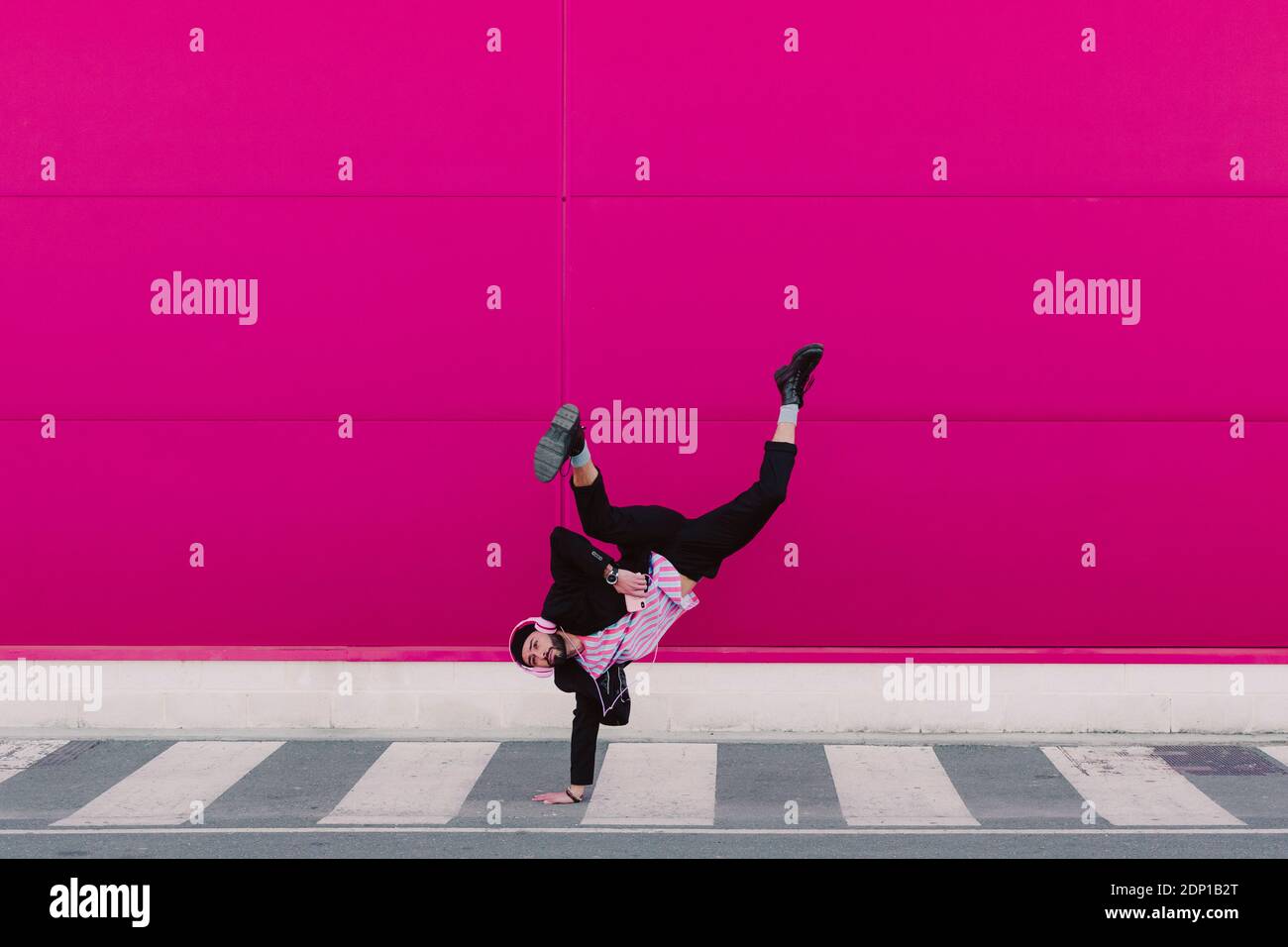 Junger Mann, der Musik hört und Breakdance tanzt Stockfoto