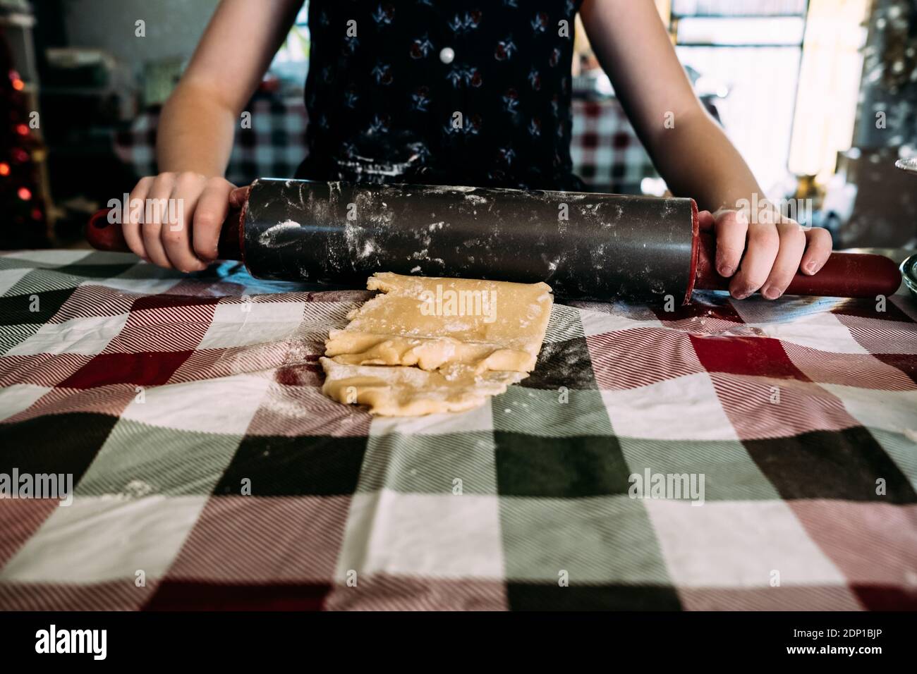 Nahaufnahme von jungen Mädchen Ausrollen Cookie Teig an Esstisch Stockfoto