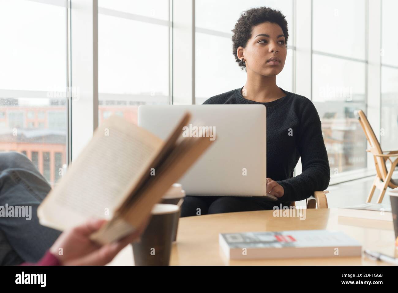 Frau mit Laptop in der Bibliothek Stockfoto
