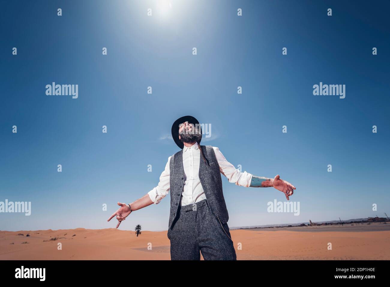 Mann mit Bart und Hut in den Dünen der Wüste von Marokko schreien Stockfoto