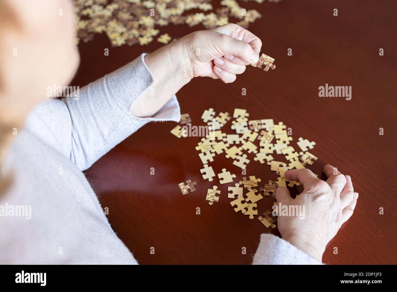 Hände und Puzzleteile auf einem Tisch Stockfoto