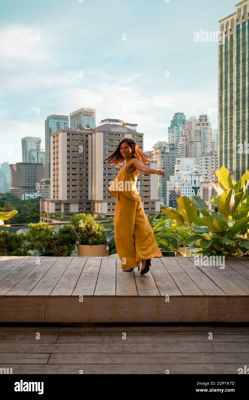 Glückliche Frau tanzen auf der Dachterrasse, Bangkok, Thailand Stockfoto