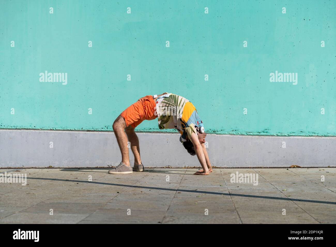 Casual Mann tun Vollrad vor der grünen Wand Stockfoto