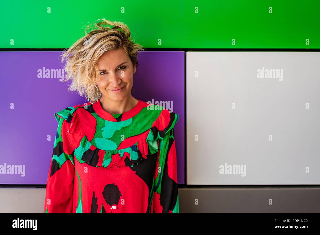 Weibliche Köchin in lässiger Stellung gegen bunte Wand Stockfoto