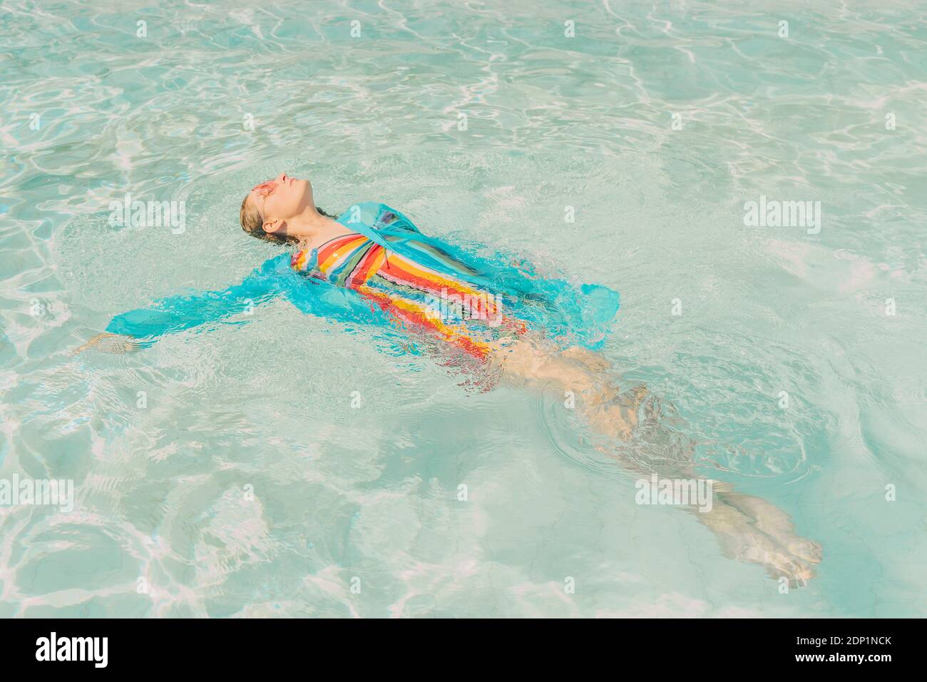 Gekleidete Frau schwimmt auf dem Wasser im Schwimmbad Stockfoto