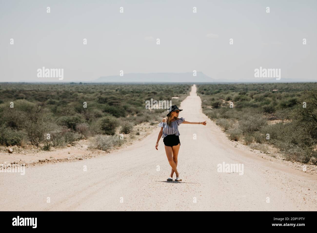 Namibia, Frau per Anhalter auf dem Weg zur Spitzkoppe Stockfoto