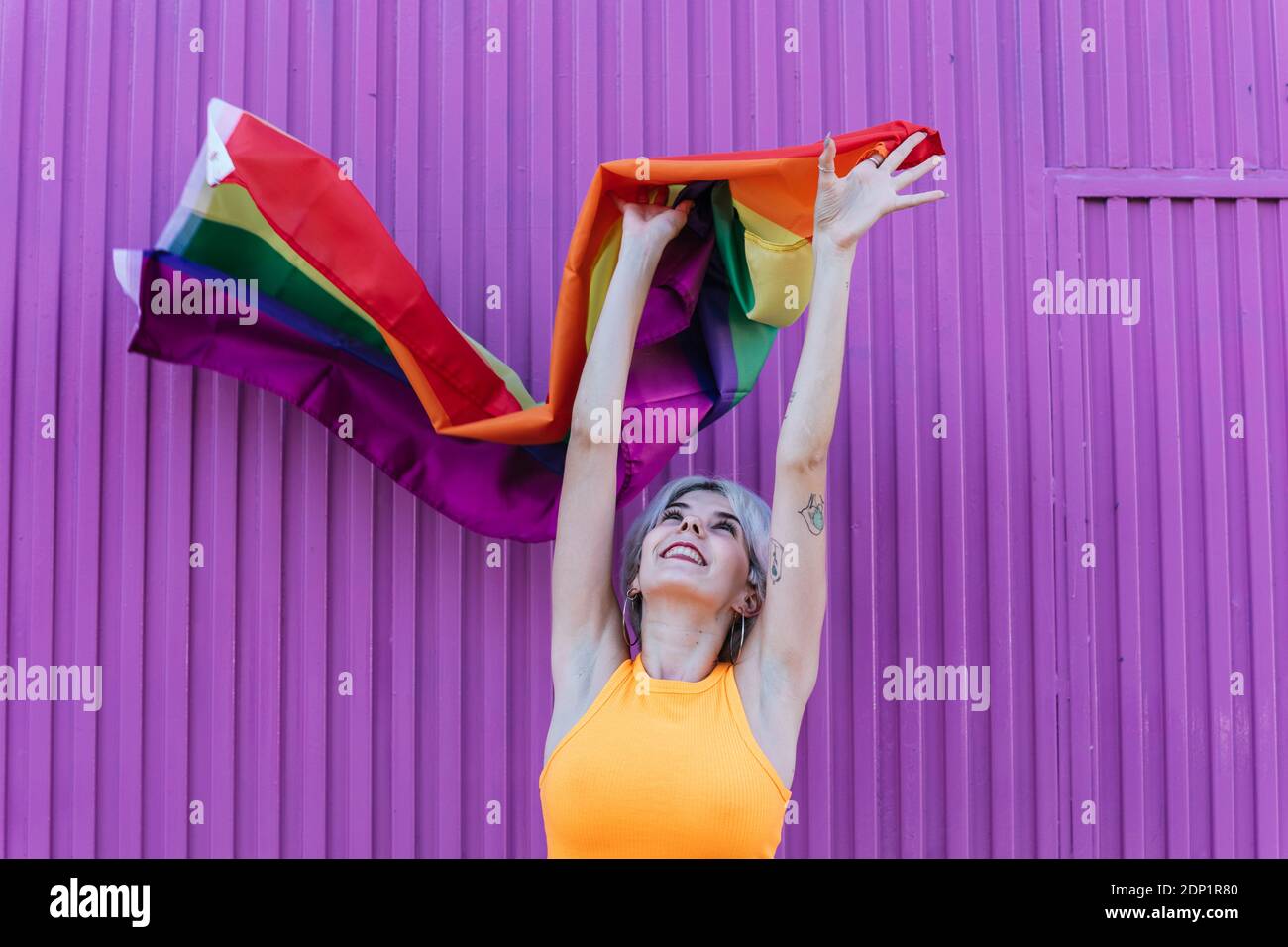 Glückliches Mädchen mit LGBT-Flagge in Granada, Spanien Frau junge Blondine 'Gen Z' bunten Stolz lgtbi lila Stockfoto