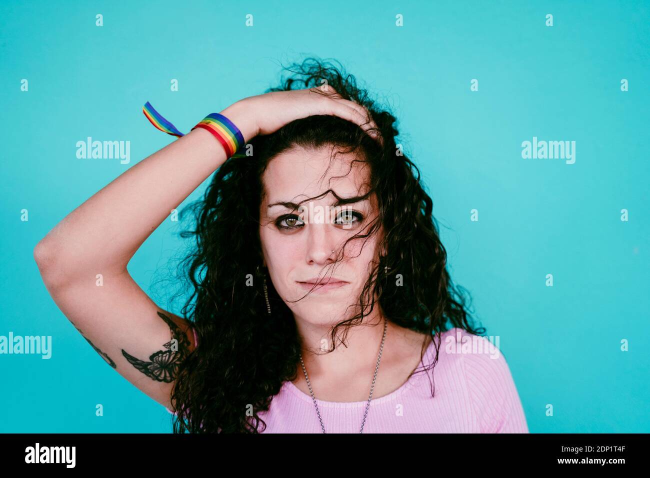 Nahaufnahme einer lächelnden jungen Frau mit der Hand im Haar Blaue Mauer in der Stadt Stockfoto