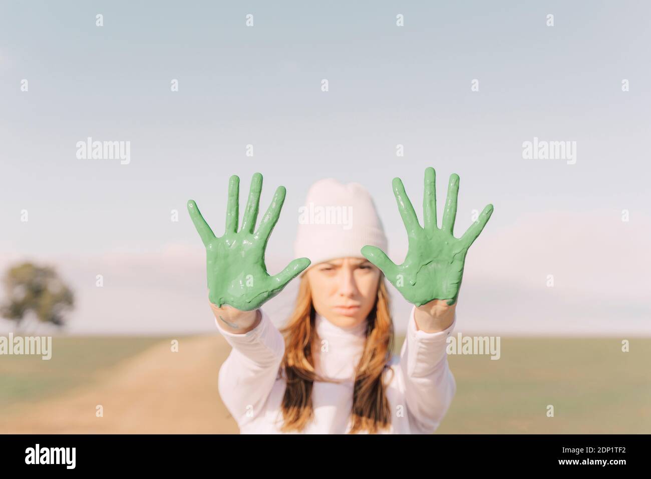Junge Frau mit grün bemalten Palmen Stockfoto