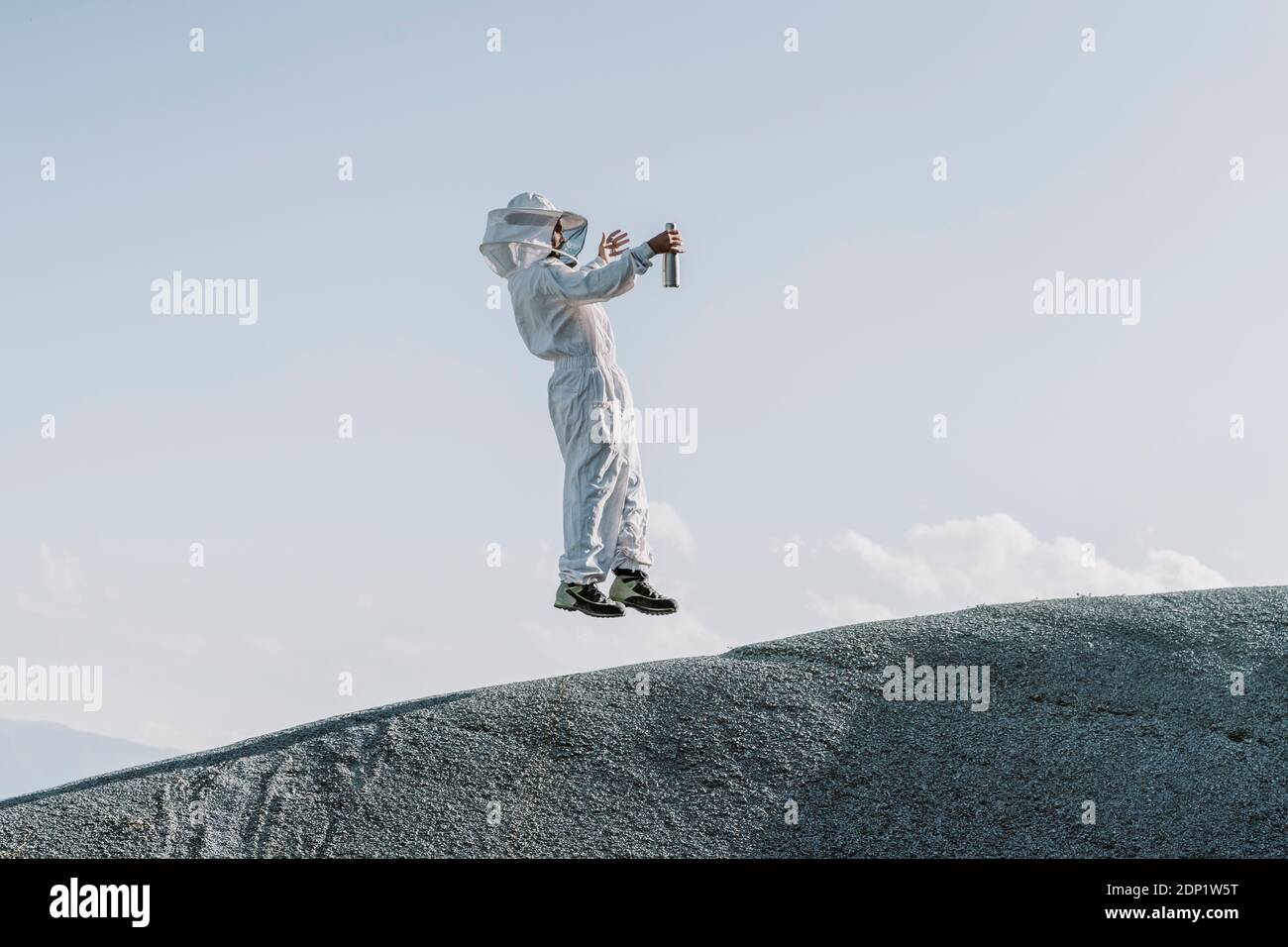 Mann in einem Imkerkleid, der auf einem Hügel springt Stockfoto