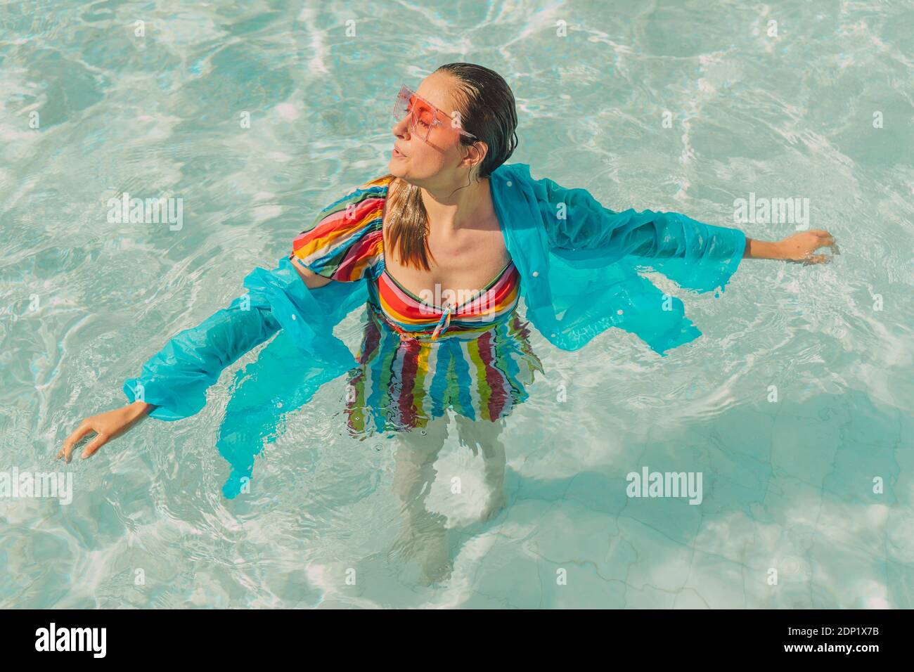 Gekleidete Frau, die sich im Pool entspannt Stockfoto