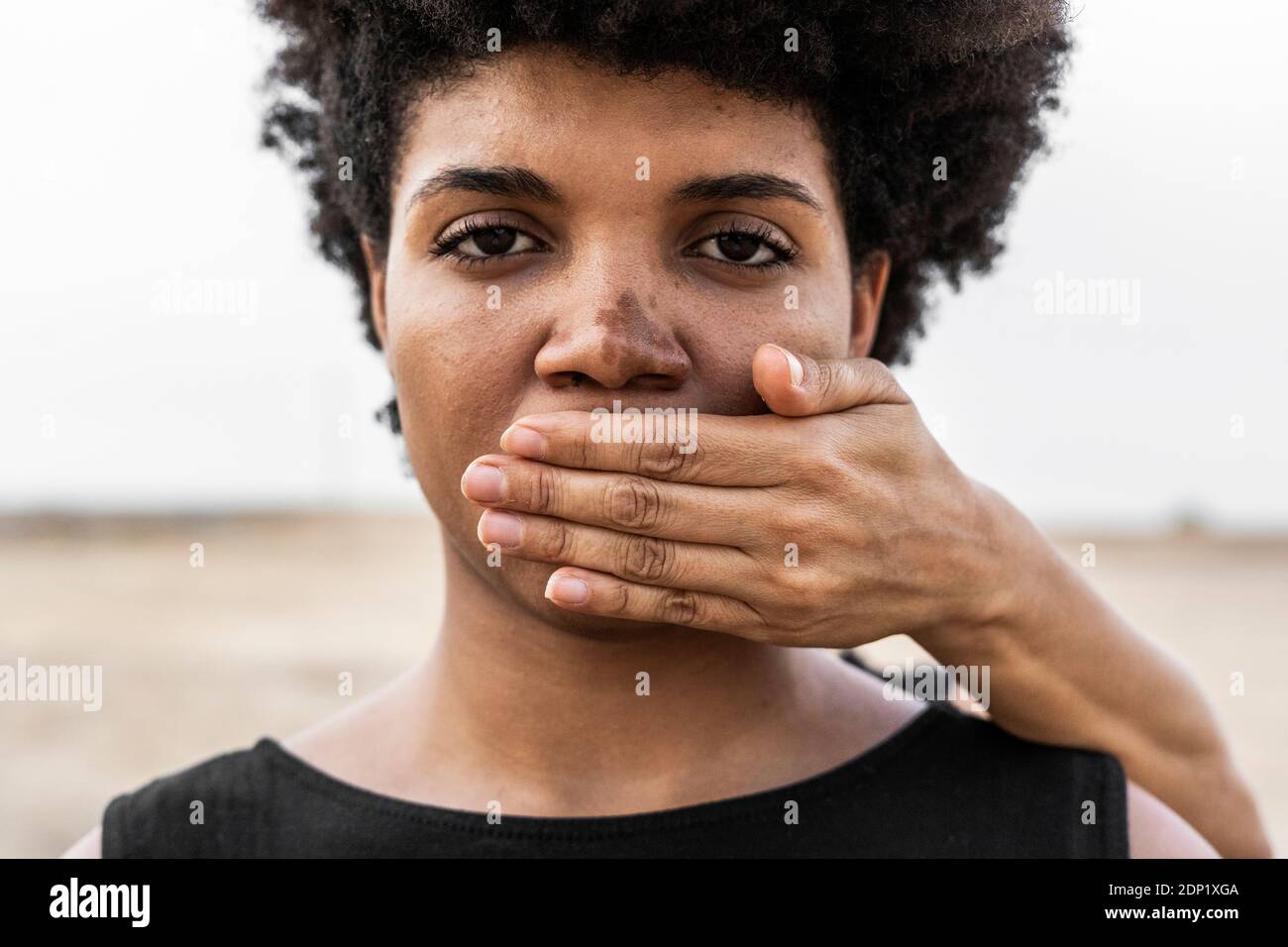 Hand in den Mund der Frau von einer anderen Frau, close-up Stockfoto