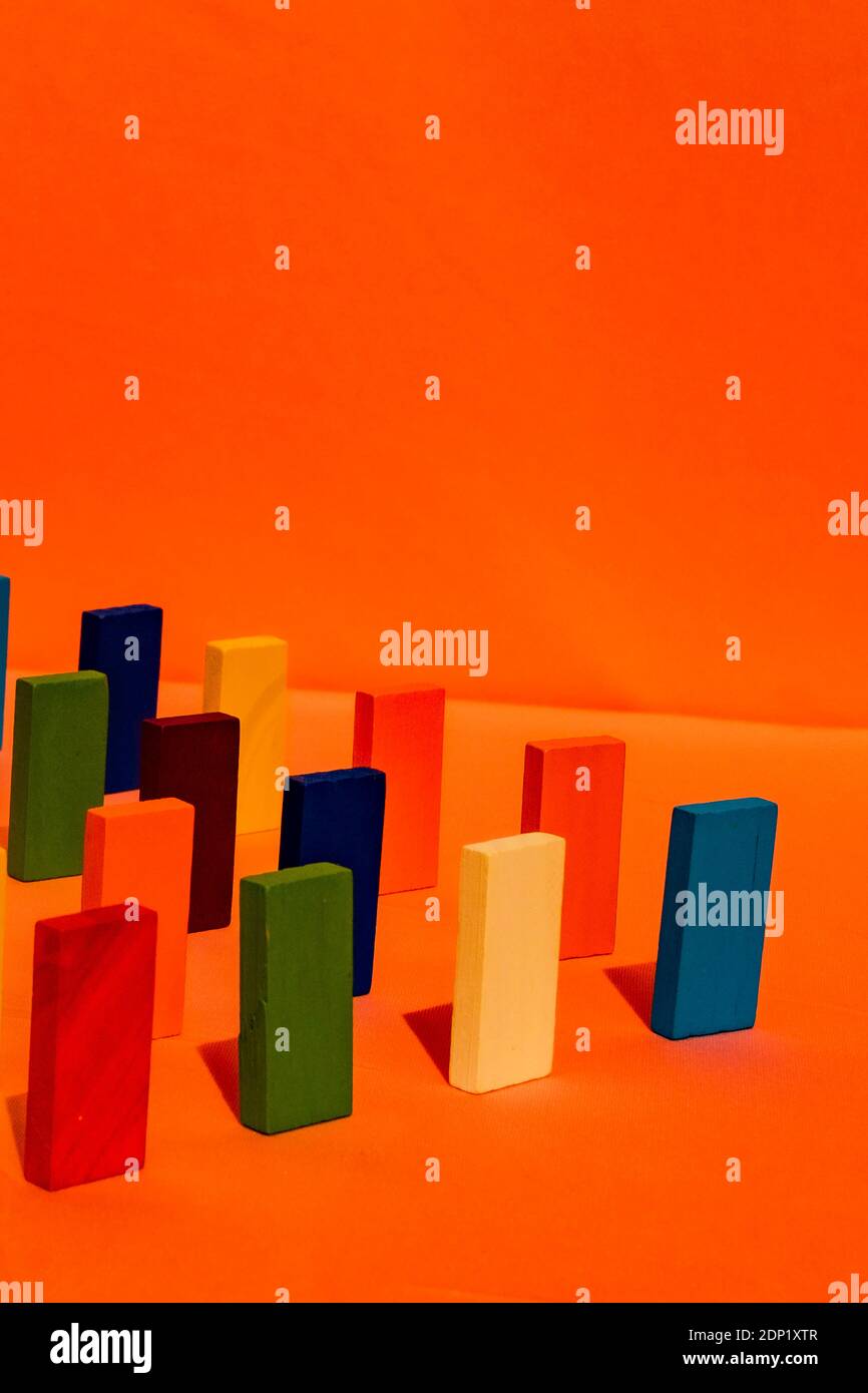 Mehrfarbiger rechteckiger Spielzeugblock vor orangefarbenem Hintergrund Stockfoto