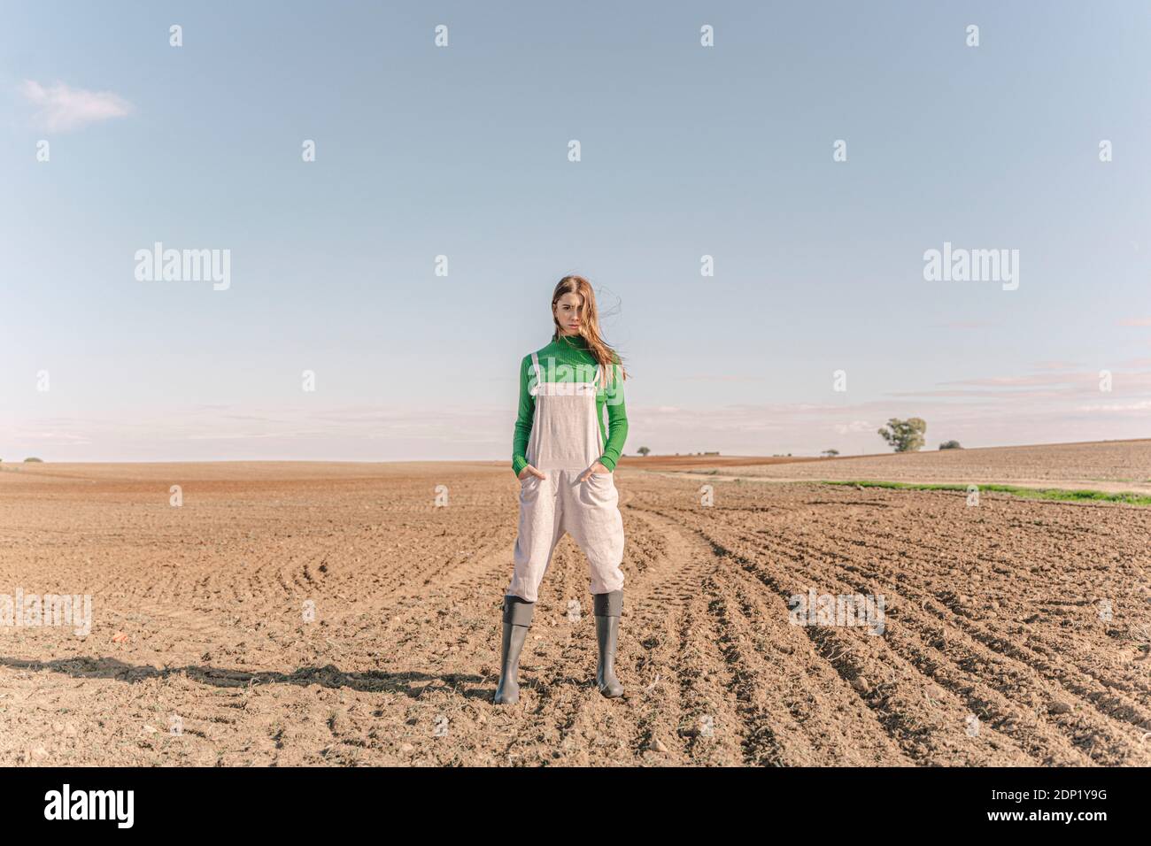 Junge Frau steht auf trockenem Feld Stockfoto