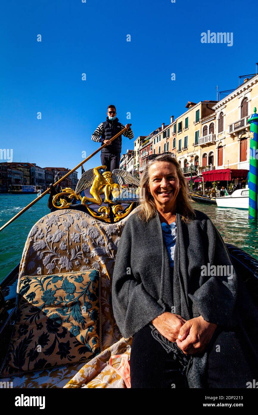 Eine Frau, die eine Gondelfahrt macht, der Canal Grande, Venedig, Italien. Stockfoto