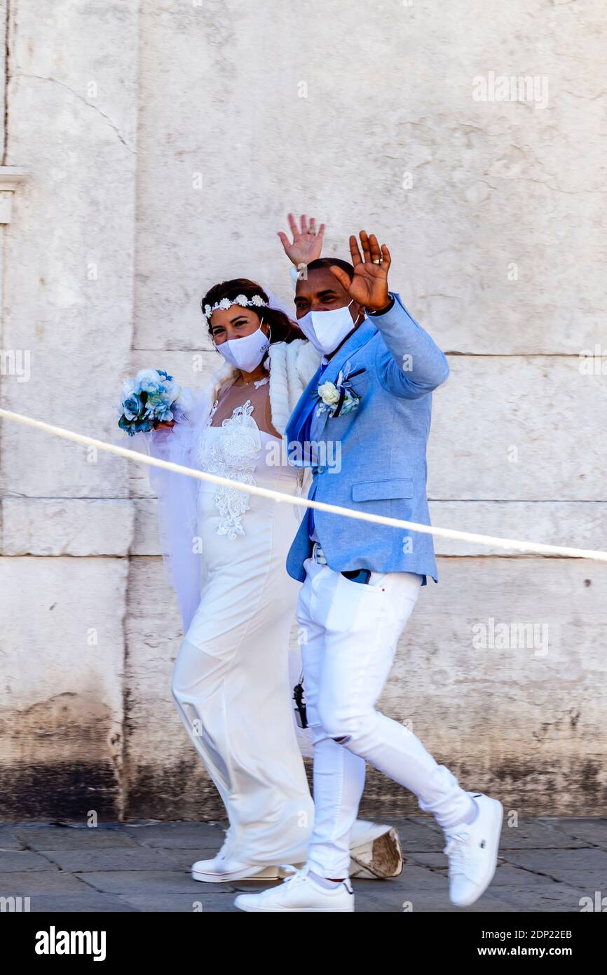 Ein frisch verheiratetes Paar winkt bei Wellwishers, Venedig, Italien. Stockfoto