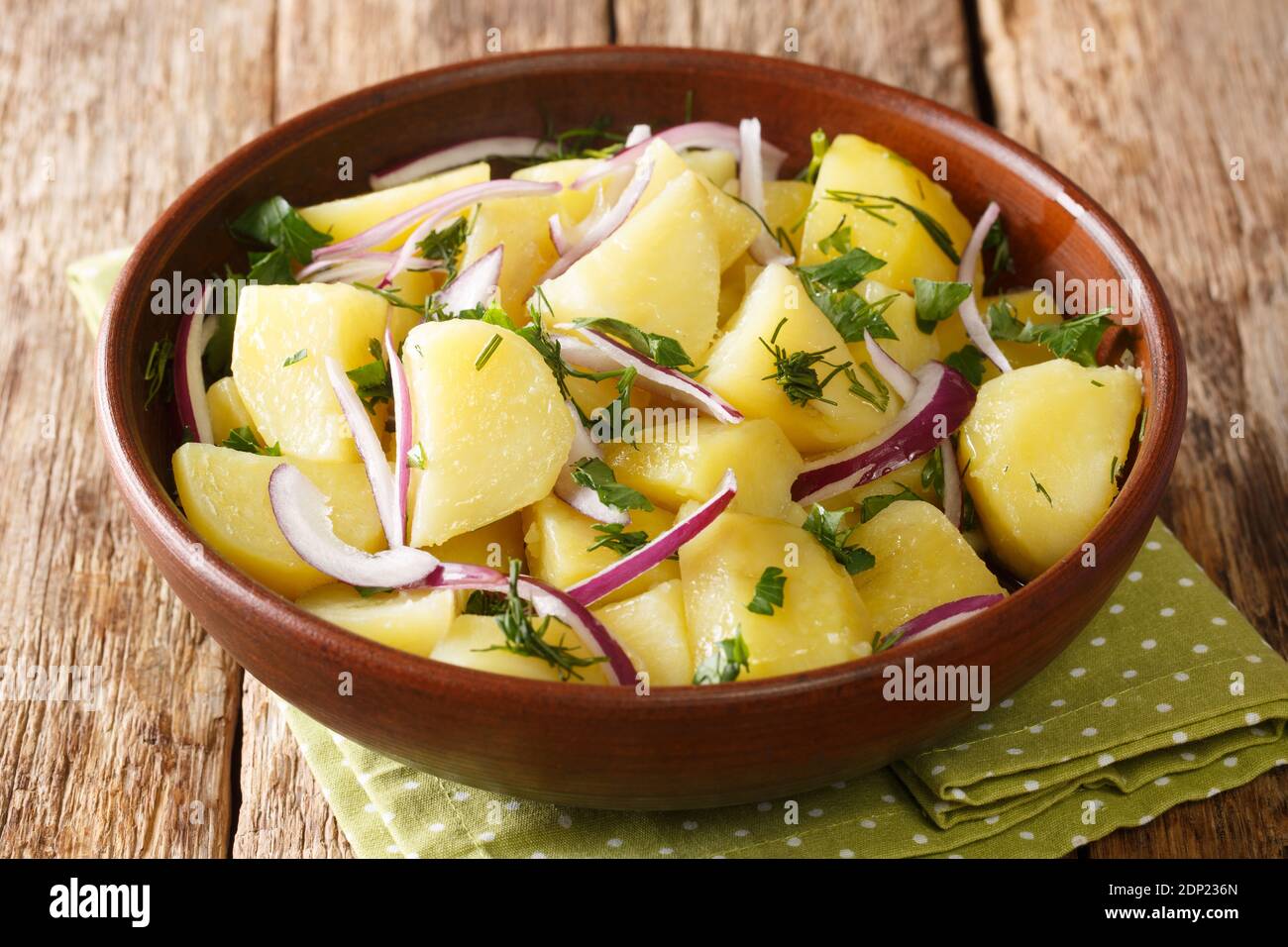 Beliebtes griechisches Rezept: Ein gesunder Kartoffelsalat aus Olivenöl und Kräutern aus der Nähe in einer Schüssel auf dem Tisch. Horizontal Stockfoto