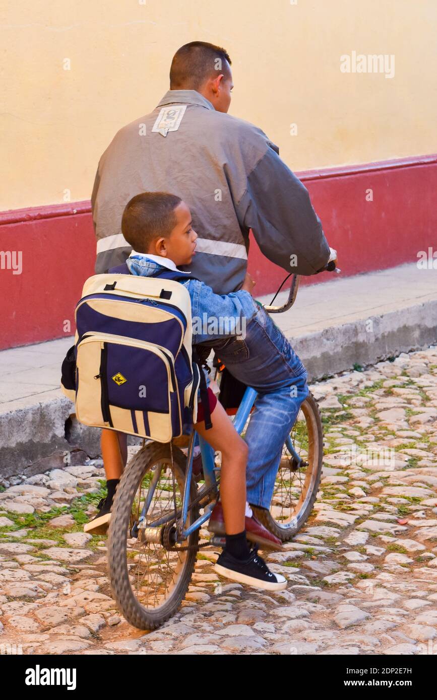 Vater mit Kind auf dem Fahrrad zur Schule, Trinidad, Kuba Stockfoto