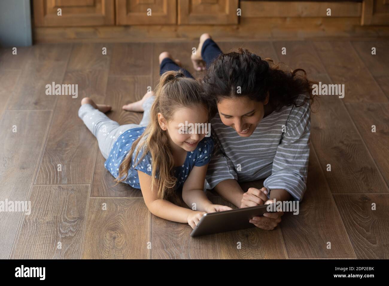 Glückliche kleine Tochter und Mama mit Bildung App auf Tablet Stockfoto