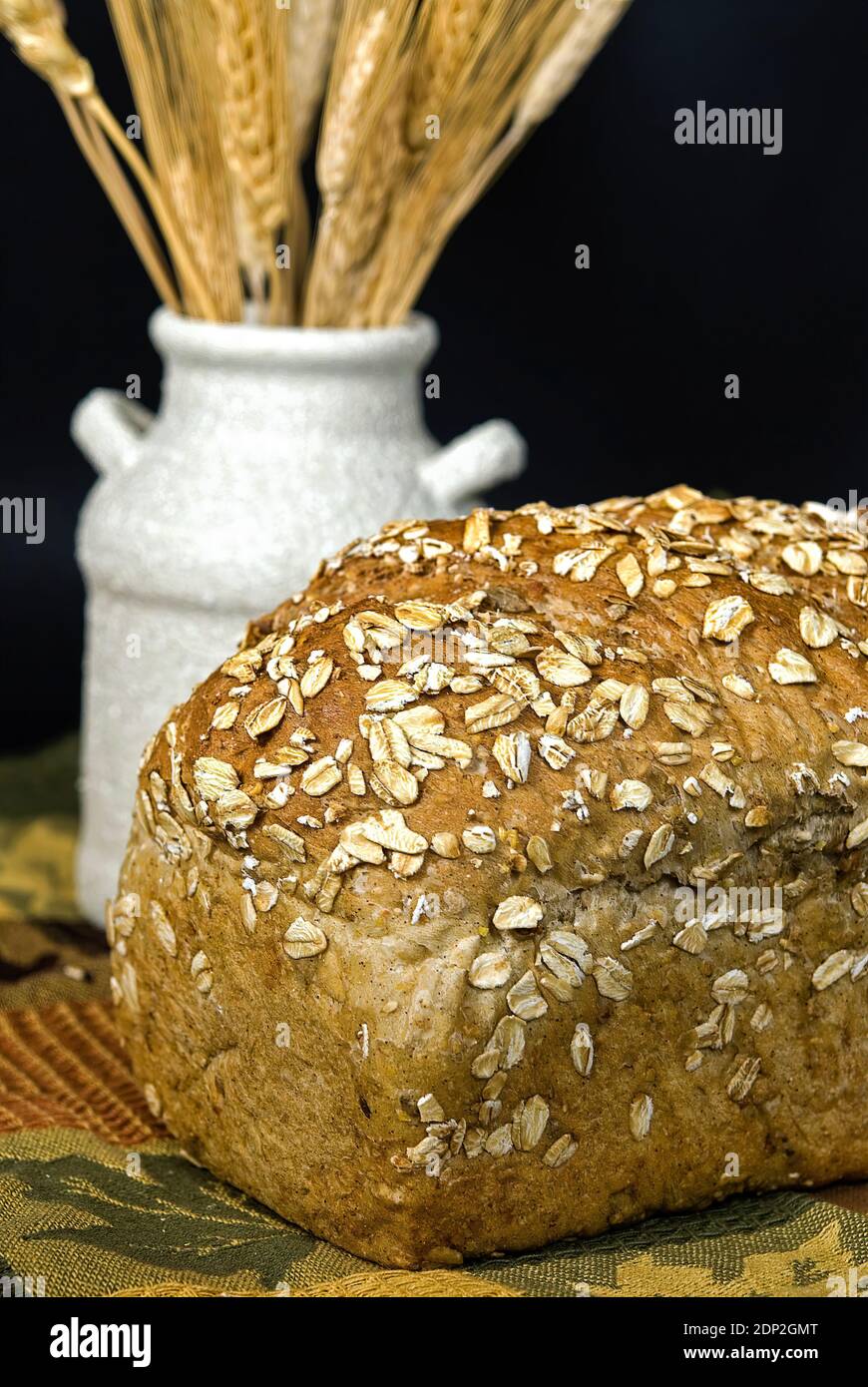 Nahaufnahme von Vollkornbrot mit Weizenstielen in Vase Stockfoto