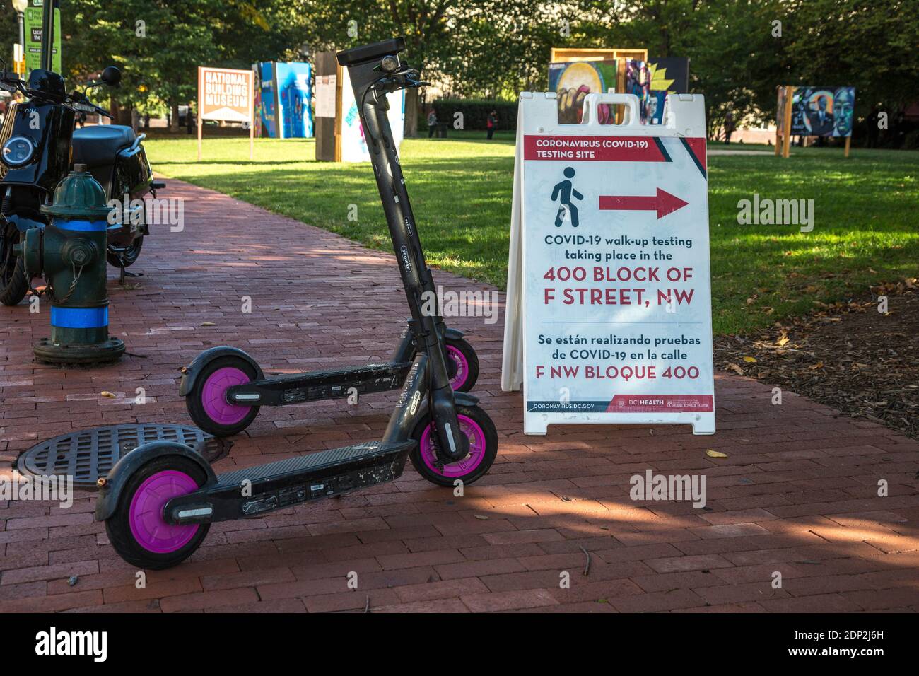 COVID-19 Prüfstelle zweisprachige Zeichen und Vermietung Elektro-Scooter, Washington DC, USA, Oktober 2020. Stockfoto
