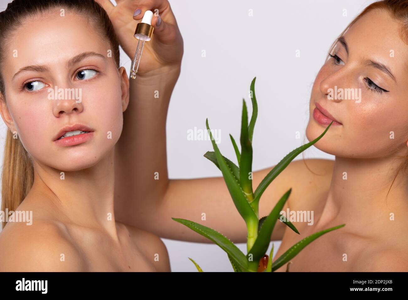 Mädchen mit sauberer und feuchtigkeitsspendender Haut. Serum und Aloe Vera Blume. Beauty-, Spa- und Gesundheitskonzept, auf weißem Hintergrund Stockfoto