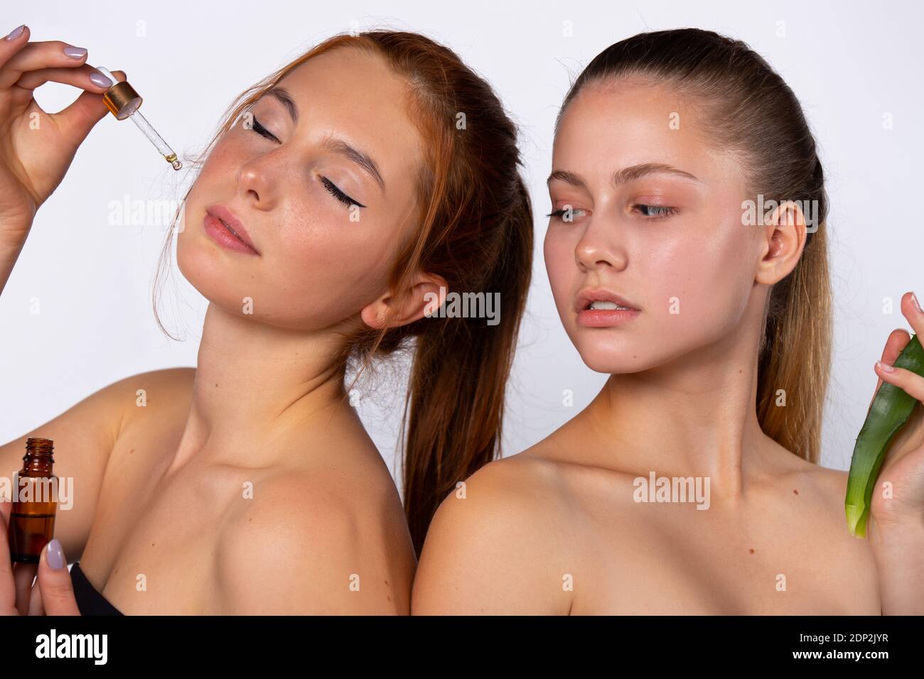 Junge Mädchen posieren für die Kamera mit Aloe Vera Blatt und Serum. Beauty-, Spa- und Gesundheitskonzept, auf weißem Hintergrund Stockfoto