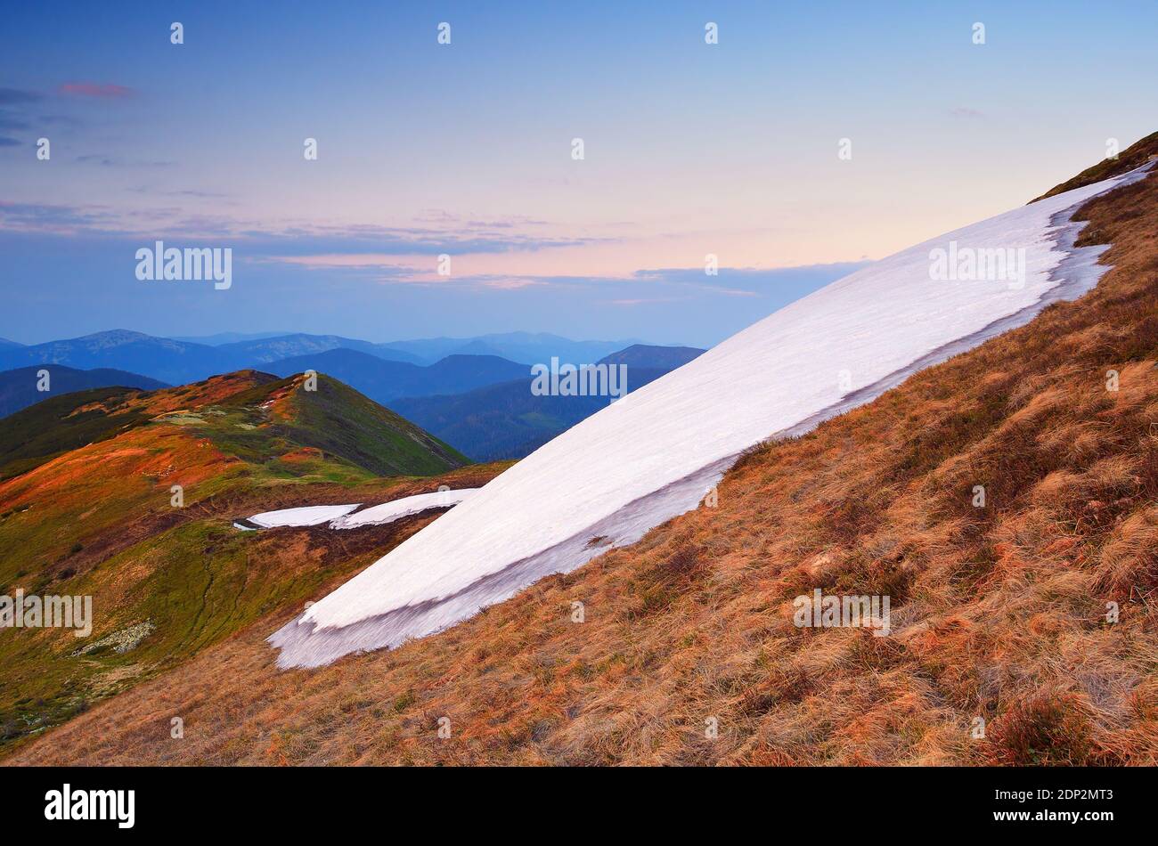 Frühlingslandschaft in den Bergen. Schneefeld auf einem Berghang Stockfoto