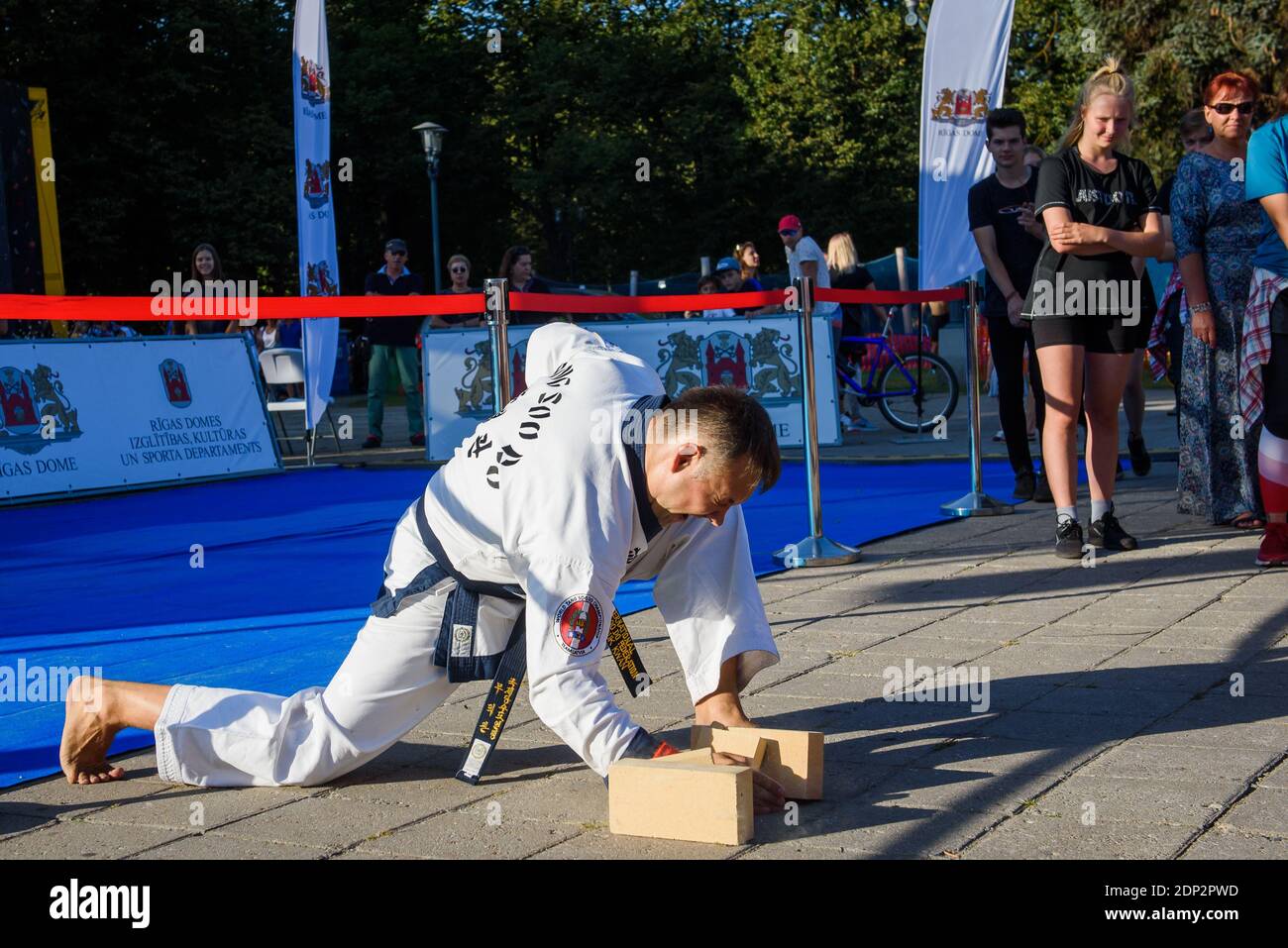 RIGA, LETTLAND. August 2019. Tang Soo macht die Meisterleistung der Kampfkunst. Ziegel brechen. Stockfoto