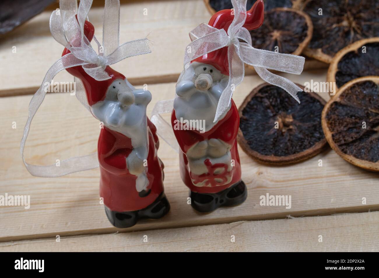 Rote Weihnachtsmänner auf rustikalen Holzbrettern als Weihnachtsschmuck. Stockfoto