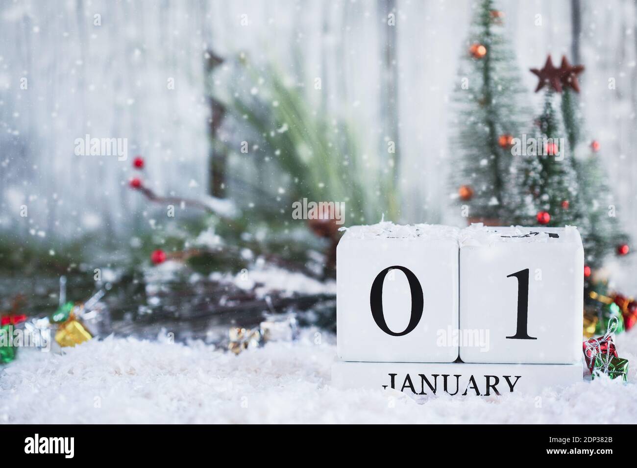 Neujahr. Weiße Holz Kalenderblöcke mit dem Datum 1. Januar und Weihnachtsdekorationen mit Schnee. Selektiver Fokus mit unscharfem Hintergrund. Stockfoto