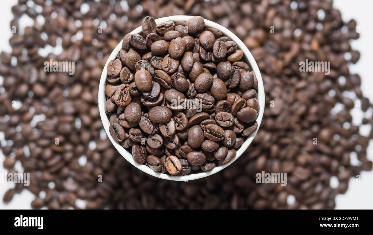 Duftende geröstete Kaffeebohnen.geröstete Kaffeebohnen Hintergrund, Kaffeeglas gefüllt mit Kaffeebohnen, Draufsicht, Nahaufnahme. Stockfoto