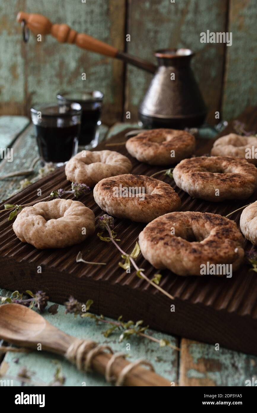 Kaffeestzeit. Hausgemachte Vollkornplätzchen und Kaffee in türkischen Topf auf Eichenbrett auf schäbig blau alten Hintergrund gebrüht Stockfoto