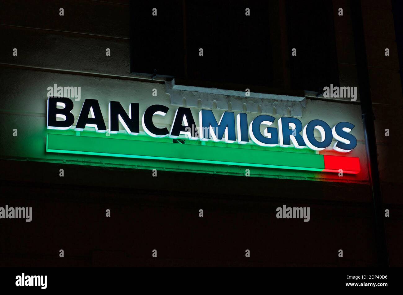 Lugano, Tessin, Schweiz - 25. November 2020 : Leuchtendes Banca Migros (auch bekannt als Migros Bank) Schild, das auf dem Gebäude in der Stadt Lugan hängt Stockfoto