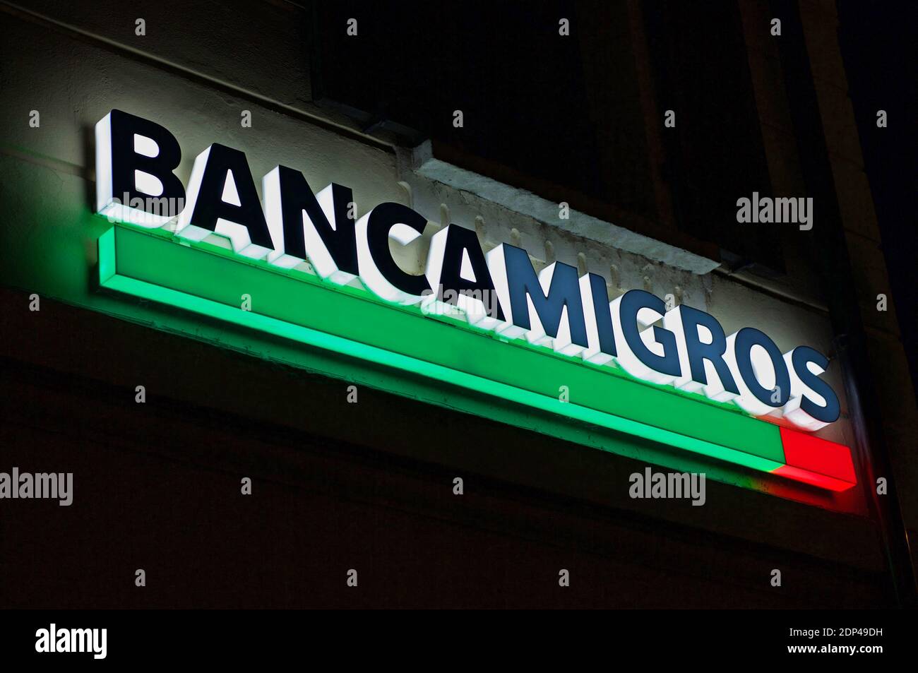Lugano, Tessin, Schweiz - 25. November 2020 : Leuchtendes Banca Migros (auch bekannt als Migros Bank) Schild, das auf dem Gebäude in der Stadt Lugan hängt Stockfoto