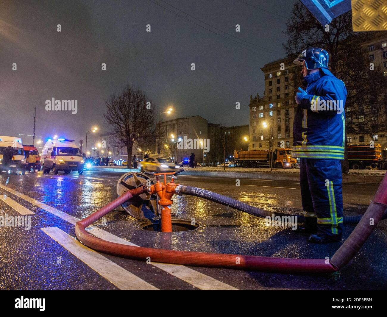 Feuerwehrmann am Hydranten gesehen. Im 7. Stock eines Bürogebäudes in der Nähe des Zentrums von Moskau brach ein Großbrand aus. Das Feuer breitete sich auf das Dach aus und überdeckte eine Fläche von mehr als 300 Quadratmetern. 130 Menschen wurden aus dem Gebäude evakuiert, niemand wurde verletzt und die Brandursache ist noch unbekannt. Stockfoto