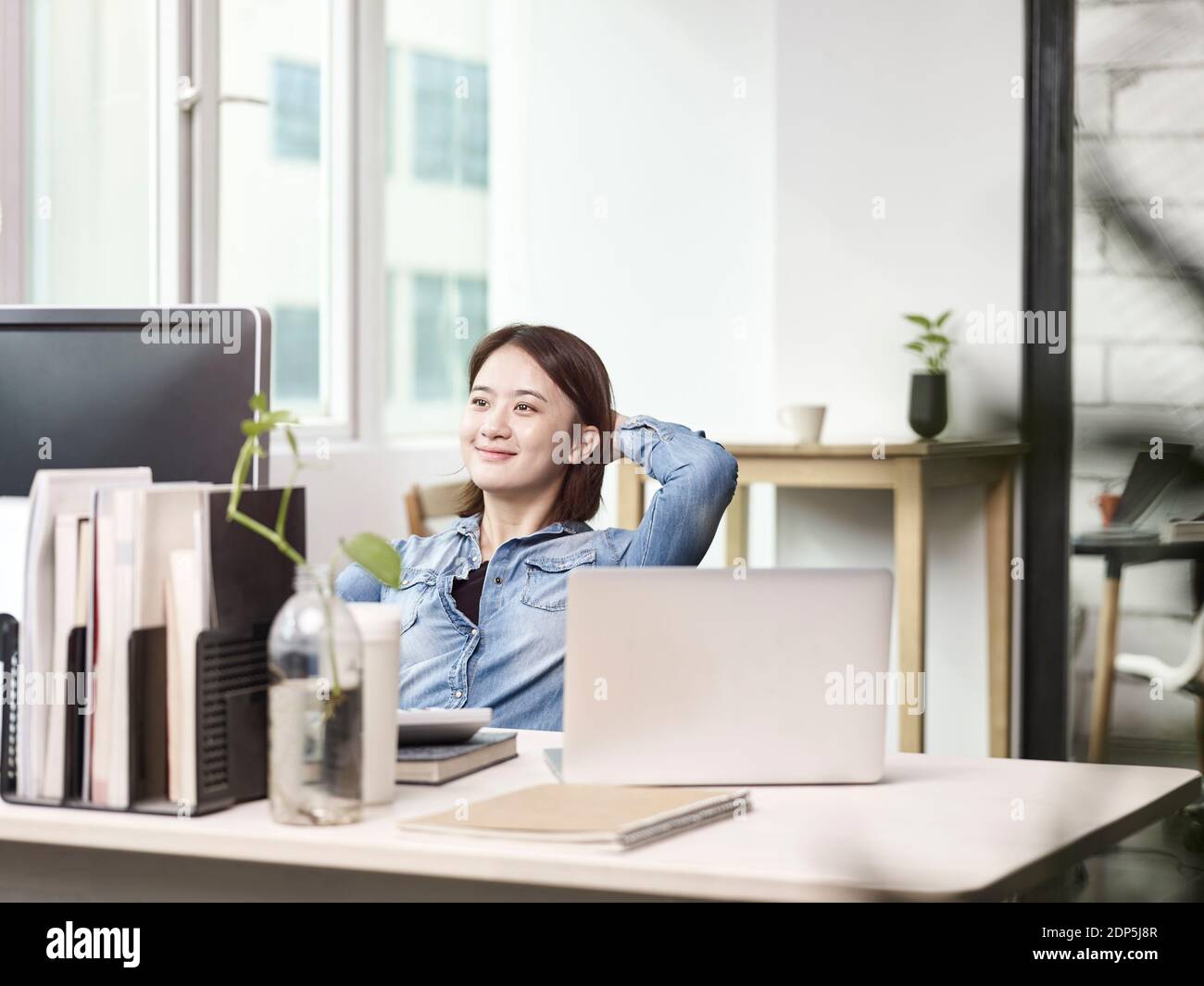 Junge asiatische Geschäftsfrau arbeitet im Büro mit Desktop-Computer Stockfoto