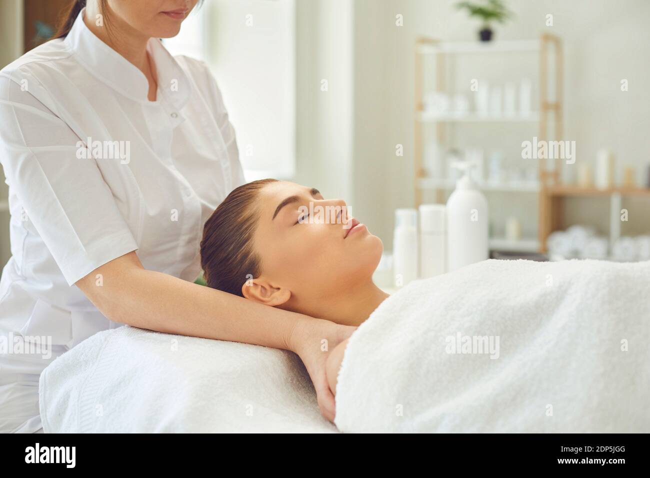 Frau Masseur macht professionelle manuelle entspannende Massage für junge Frauen Gesicht und Schultern Stockfoto