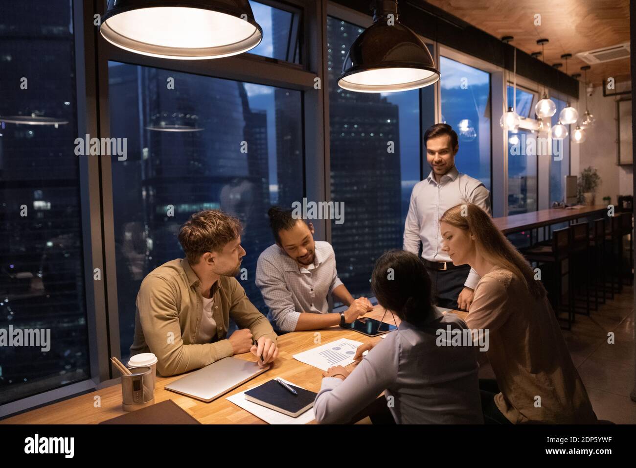 Diverse Kollegen arbeiten spät in der Nacht im Büro Stockfoto