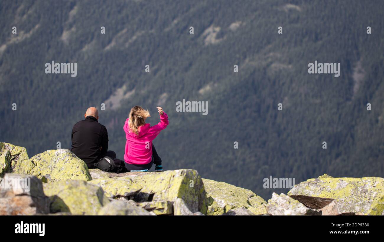 Zwei Touristen sitzen auf dem Gipfel des Berges. Stockfoto