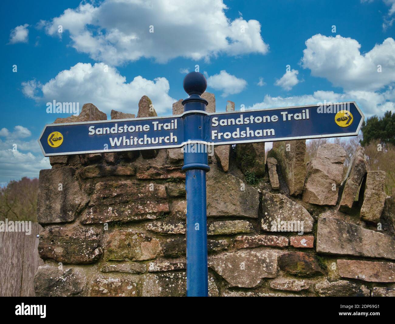 Ein blaues Metallschild, ein Weg zeigt auf Frodsham und der andere auf Whitchurch, die beiden Enden des Sandsteinweges. Stockfoto