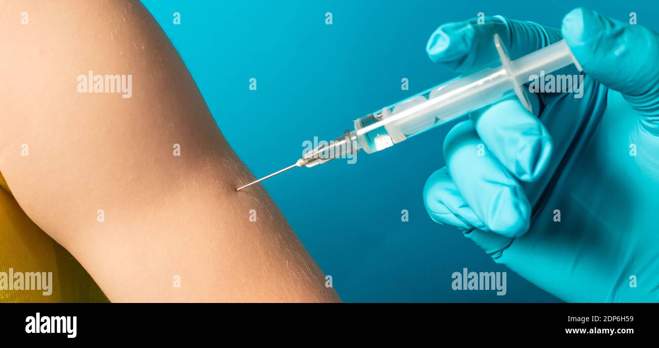 Der Arzt oder die Krankenschwester injiziert einem kleinen Kind  intramuskulär auf blauem Hintergrund eine Spritze. Tuberkulose-Impfung,  BCC-Impfung Stockfotografie - Alamy
