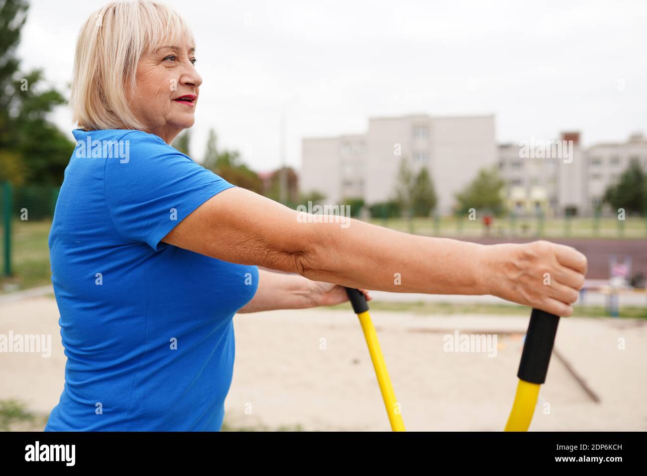 Schöne gesunde Frau 64 Jahre alt tun Übungen im Freien Stockfoto