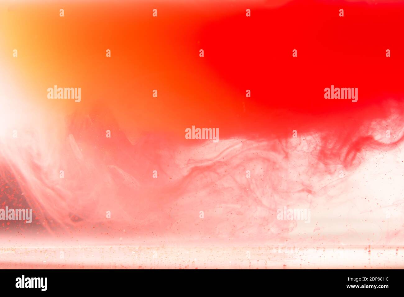 Bunte Tinte auf weißem Hintergrund.Gelb orange Tropfen wirbelnd unter Wasser. Wolke von Acrylfarbe in Wasser. Stockfoto