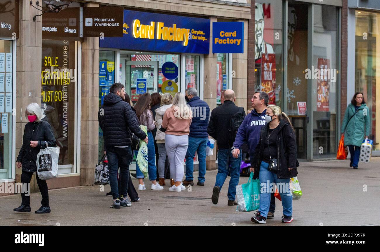 Dundee, Tayside, Schottland, Großbritannien. Dezember 2020. UK Wetter: Kühles und nasses Wetter in Nordostschottland mit Temperaturen bis 8 Grad Einige Käufer tragen Gesichtsmasken, während andere ohne Gesichtsschutz stehen zusammen Schlange vor dem Card Factory Kartengeschäft entlang der Murraygate im Stadtzentrum, während Dundee Tier 3 Covid-19 Lockdown Beschränkungen erfährt, während die Coronavirus-Pandemie in der Tayside Region weiter andauert. Kredit: Dundee Photographics/Alamy Live Nachrichten Stockfoto